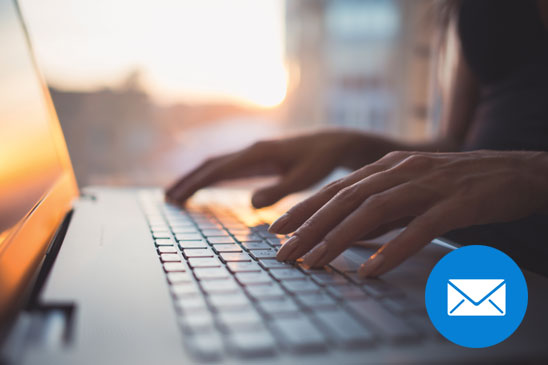 Hands typing on a keyboard as if sending an email